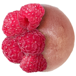 Mochi rose décoré de framboises entières et de morceaux de litchi, posé sur une surface en bois.